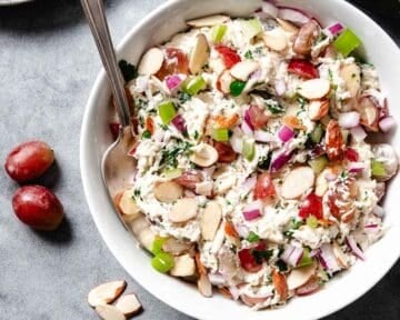 Chicken salad with grapes and sliced almonds in a bowl.