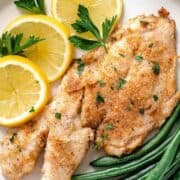 fried yellowtail with lemon and green beans on plate