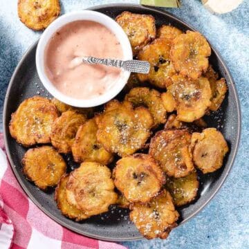 Tostones with pink sauce on plate.
