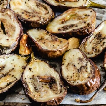 Roasted baby eggplant and garlic on sheet pan.