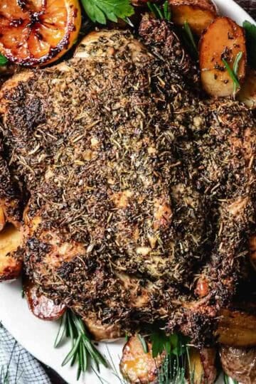 Roasted chicken on a platter with potatoes and lemons