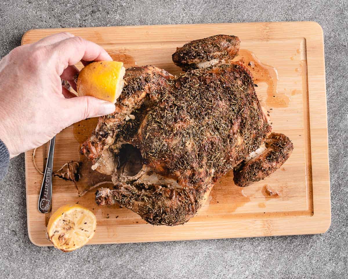 roasted chicken on a butting board with lemon