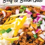 beef and bean chile in a bowl with cheese and onions
