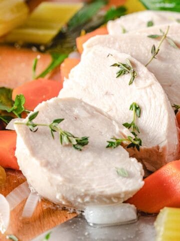 Poached chicken breasts with carrots and celery.