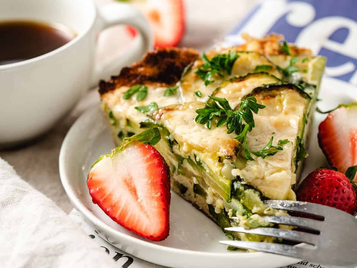 Zucchini frittata on a plate with strawberries.