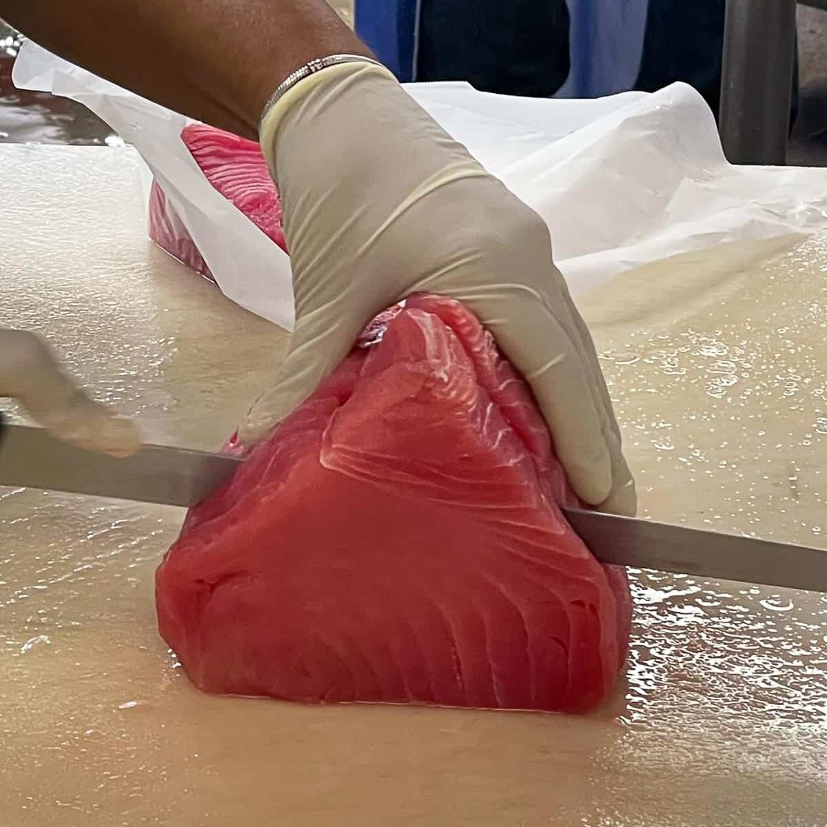 Girl cutting fresh ahi tuna.