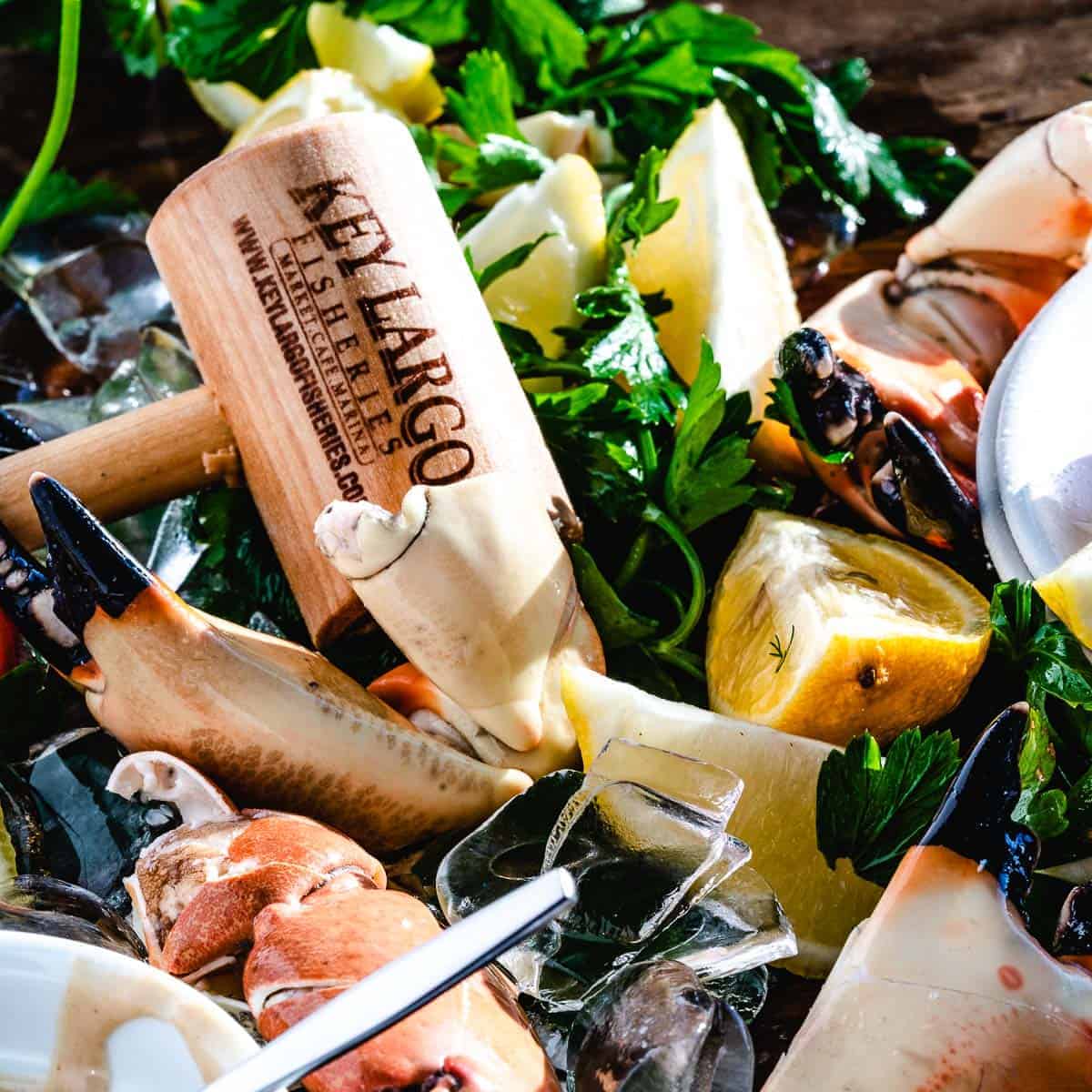 stone crab claws with mallet and lemon wedges.