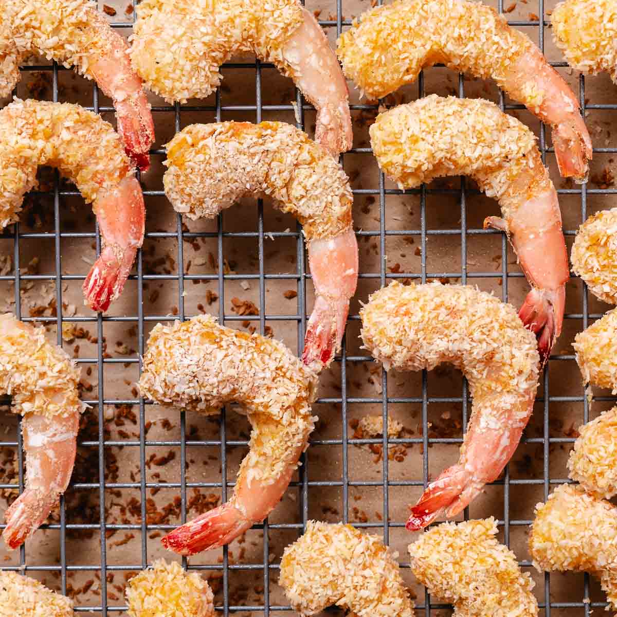 Coconut-coated shrimp arranged on a wire rack, ready for baking