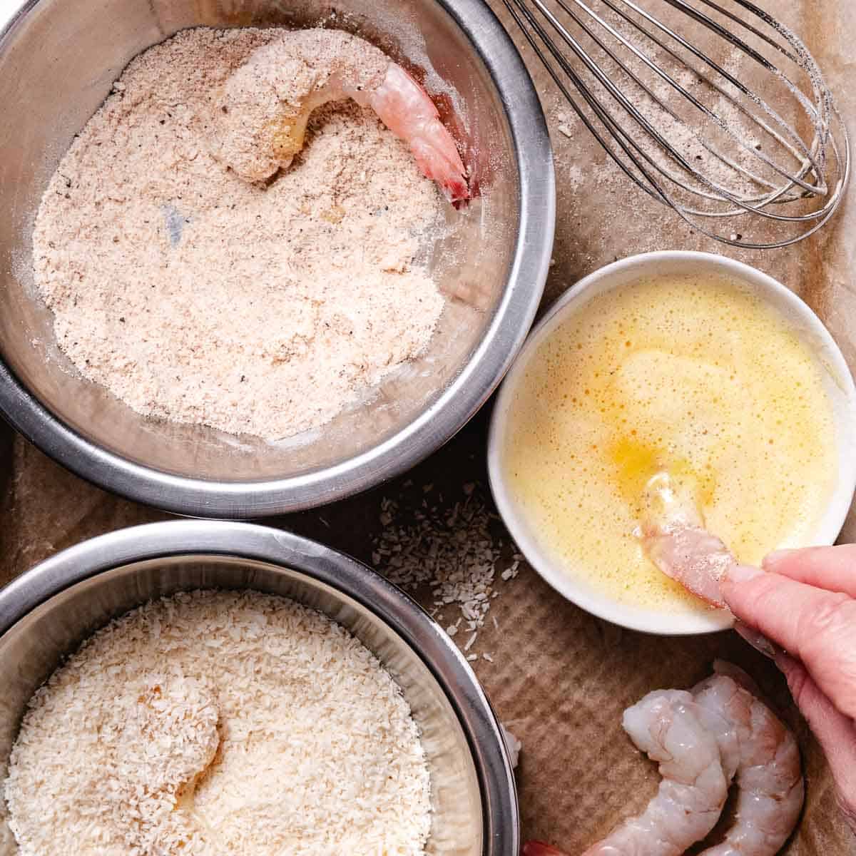Breading stations and egg for preparing coconut shrimp.