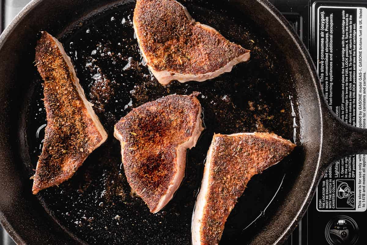 blackened swordfish cooking in cast iron pan