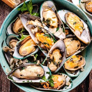 green mussels from new zealand in a dish.