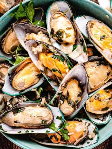 Green mussels from new zealand in a green dish.