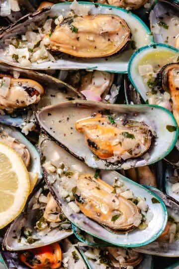 Green mussels from new Zealand in a green dish.
