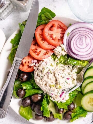 Tuna salad with lettuce and tomatoes on a plate.