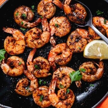Skillet blackened shrimp with garlic butter, lemon wedges, and fresh parsley.