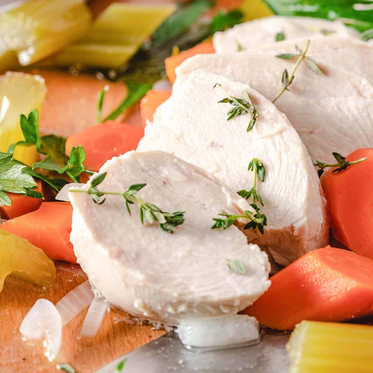 Poached chicken with carrots in a pot.