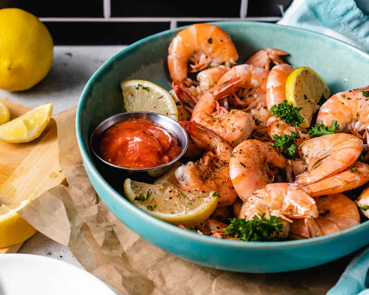peel and eat shrimp with lemon wedges in a bowl