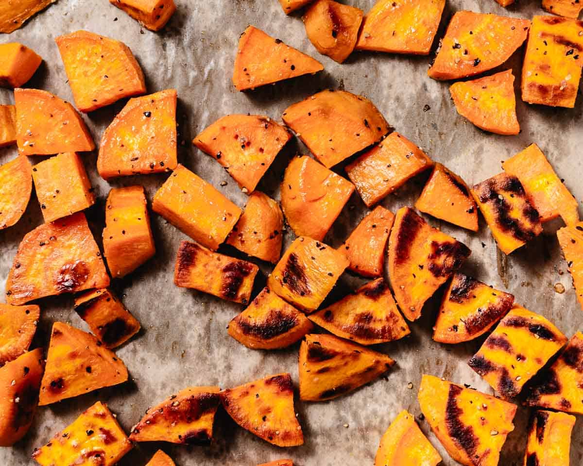 Roasted sweet potatoes fresh out of the oven. The bottoms are caramelized and dark while the tops stay golden and soft&mdash;no need to flip!