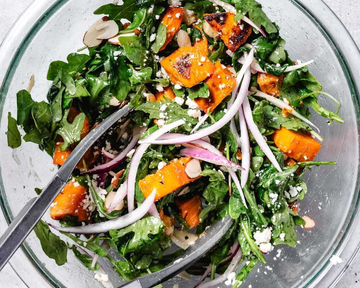 Tossing the salad ingredients together in a large bowl until evenly coated.