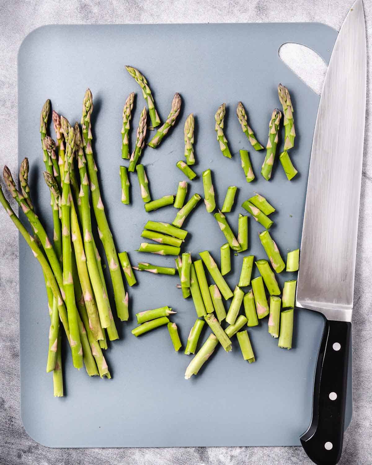How to cut asparagus on cutting board.