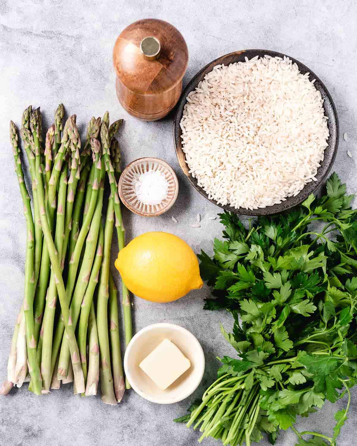 Rice, asparagus, lemon, parsley, salt, and pepper ingredients.