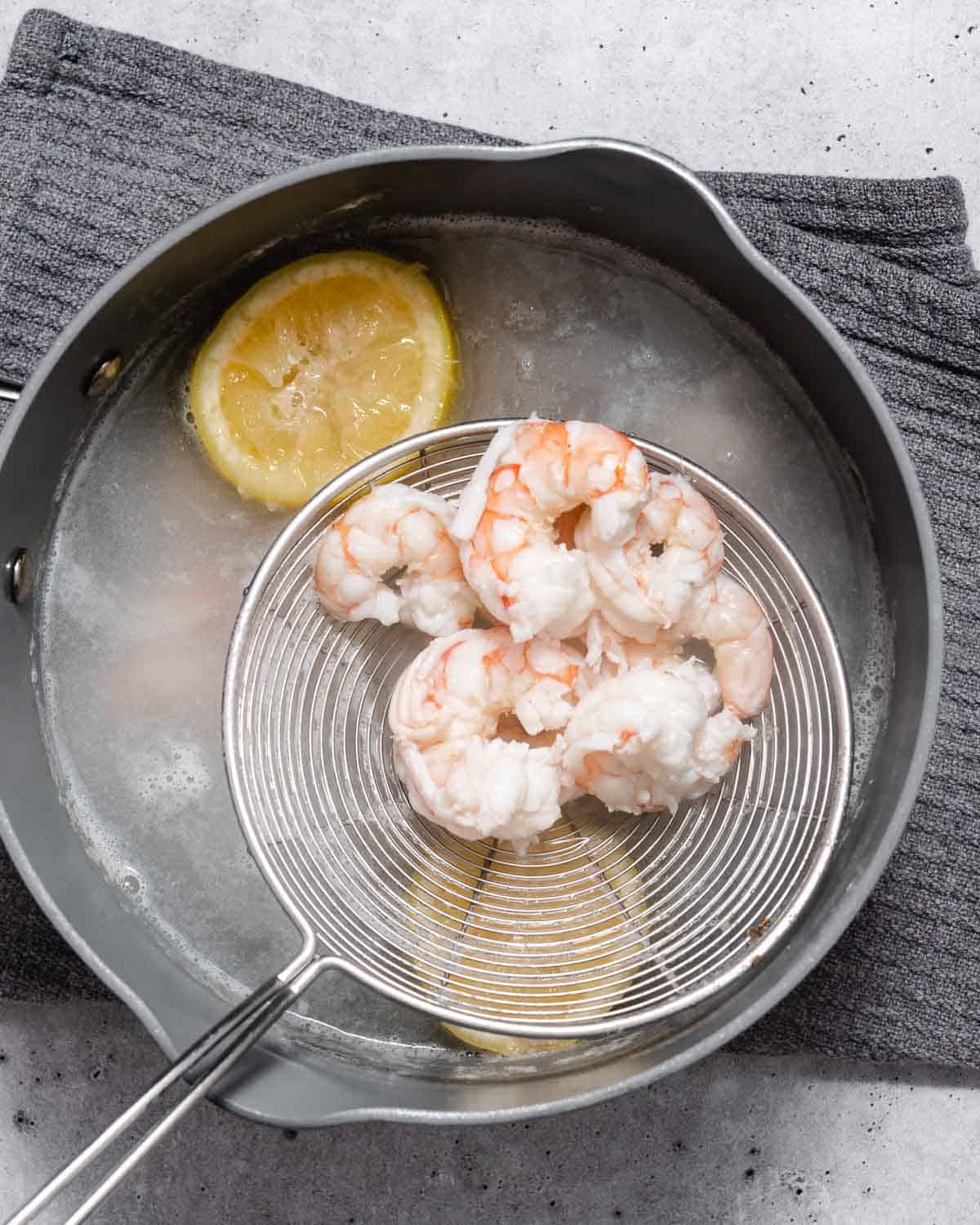 Boiling shrimp in a pot with lemon.