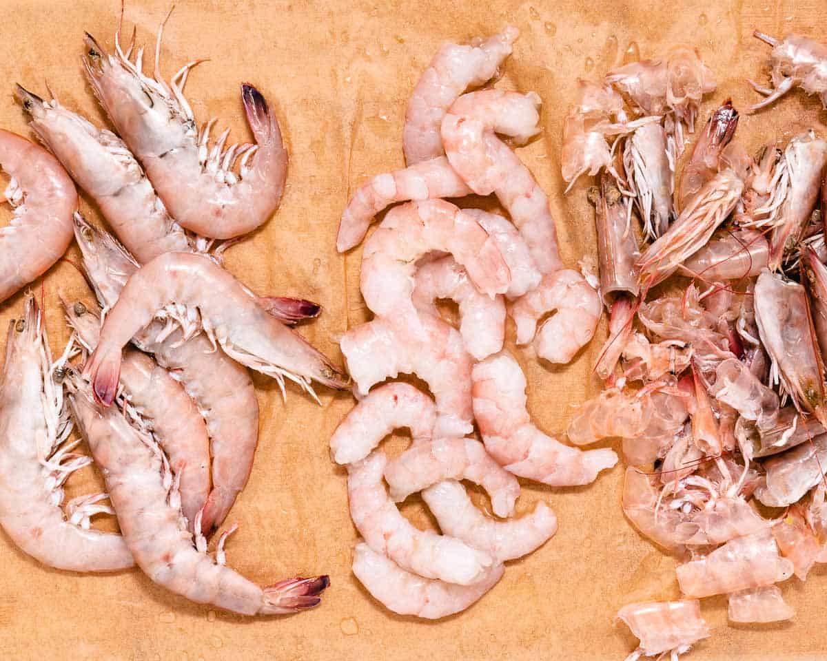Raw and peeled shrimp on a cutting board