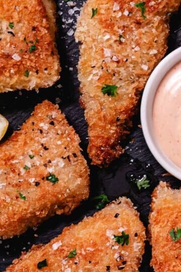 Pan fried red snapper with panko breadcrumbs, lemon wedges, and pink sauce