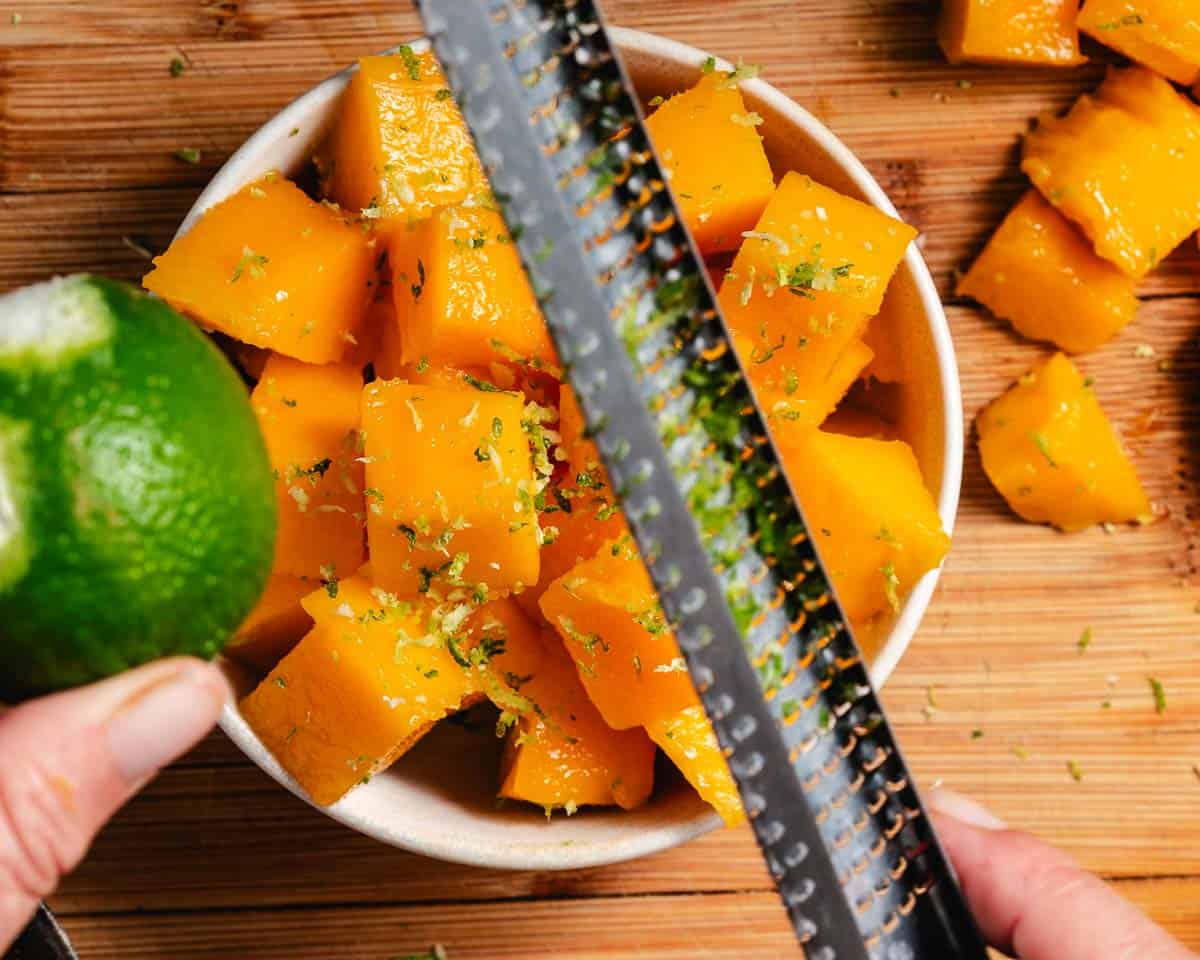 Grated lime zest over mango.