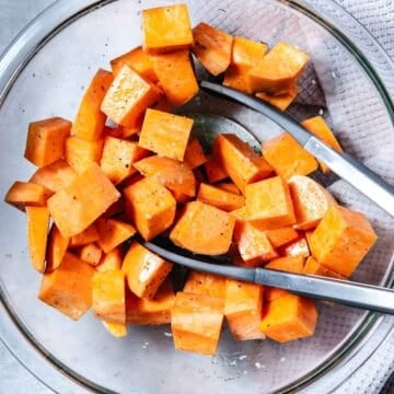 tossing sweet potato cubes with oil, salt and pepper