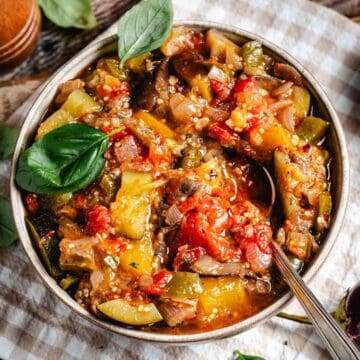 A bowl of traditional french ratatouille on beige gingham napkin.