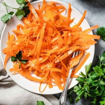 carrot salad with parsley on white plate.