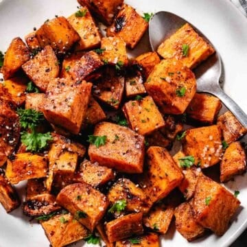 roasted sweet potatoes in a bowl with a serving spoon