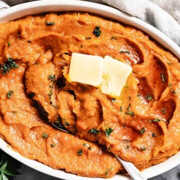 Sweet potatoes in a casserole with butter on top.