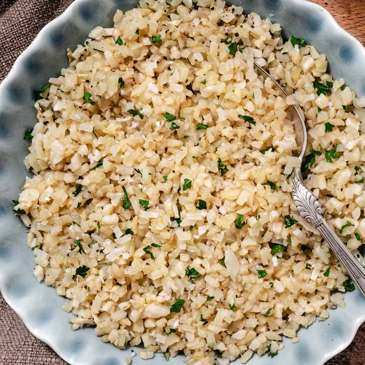 Cooked cauliflower rice in a serving bowl.