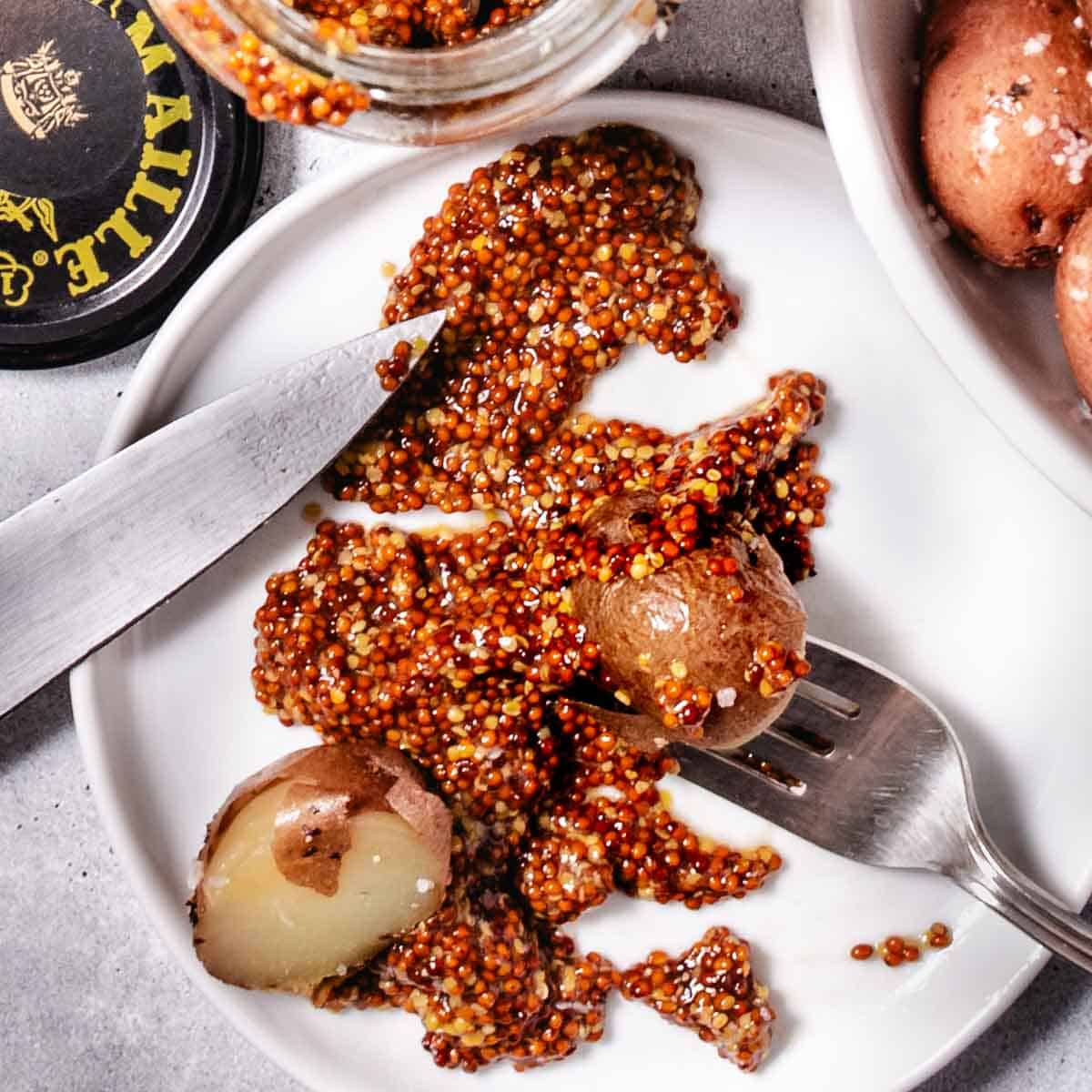 Crispy roasted red potatoes in a bowl with whole grain mustard