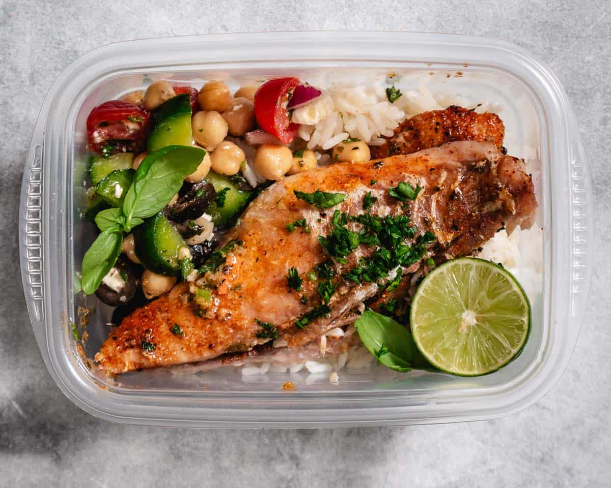 Snapper with rice and vegetables in a container
