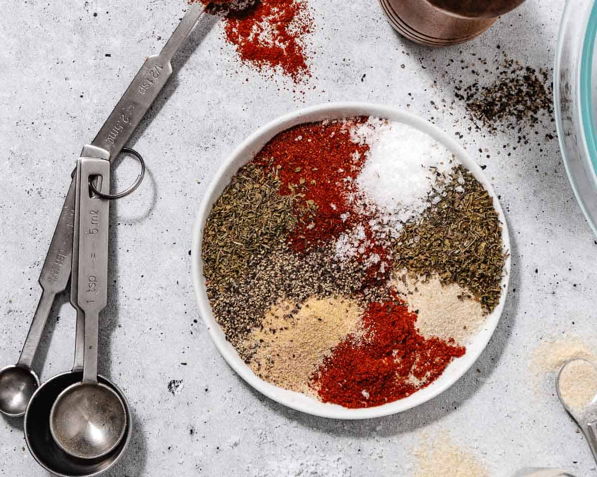 Bowl of spices with measuring spoons.