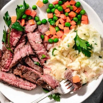 Chuck steak with peas and carrots and mashed potatoes.