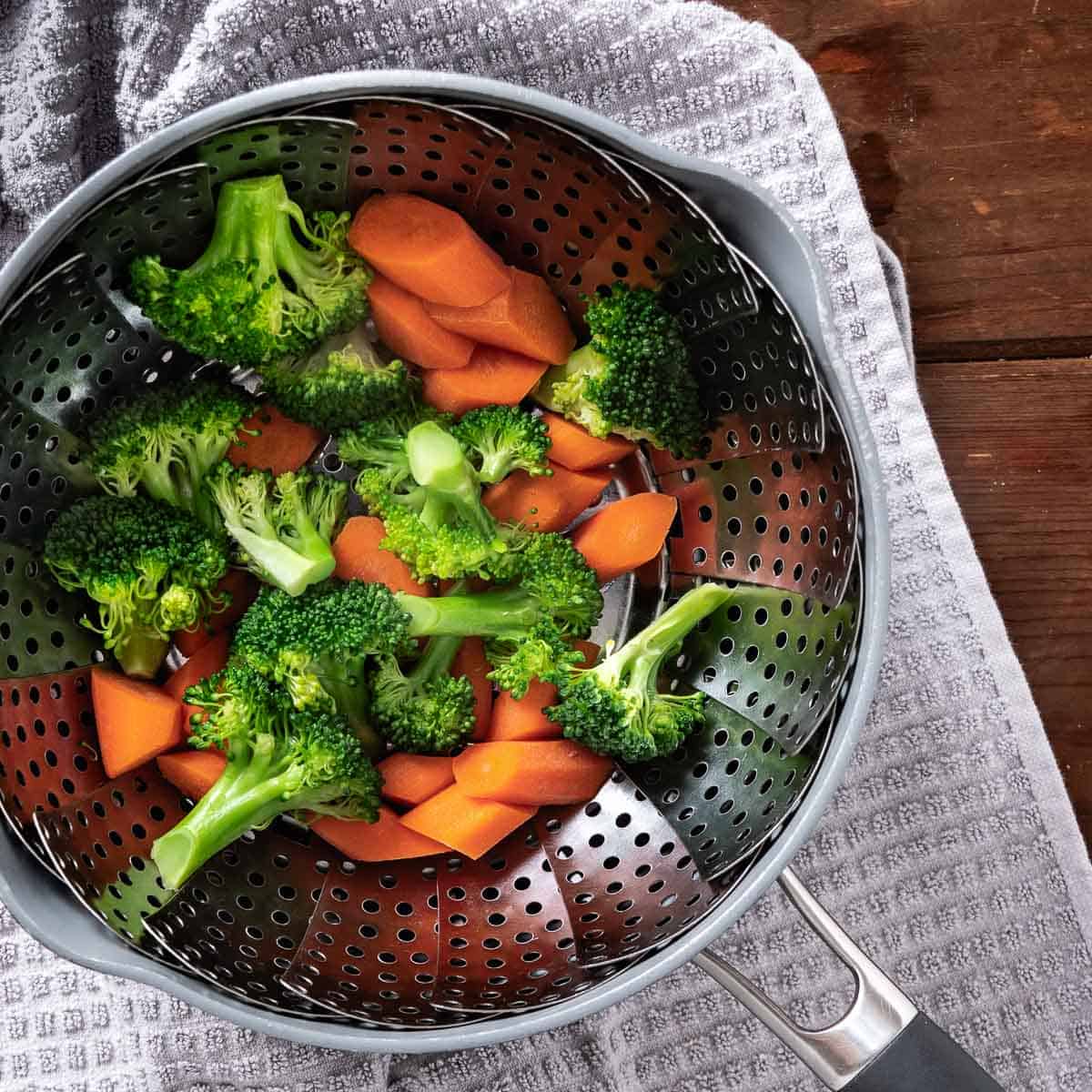 Steamed broccoli and carrots in a saucpan.