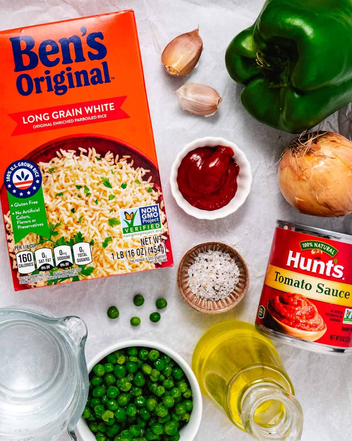 Ingredients for Spanish rice including Ben’s Original converted rice, tomato sauce, peas, green bell pepper, onion, garlic, ketchup, olive oil, salt, and water.