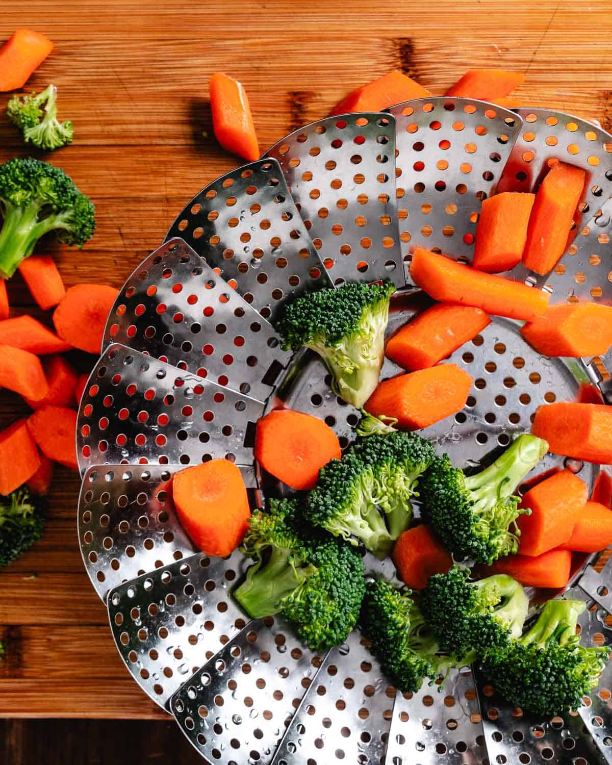 Steaming broccoli and carrots in a steamer basket.