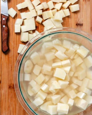 Cubed potatoes in a bowl of water.