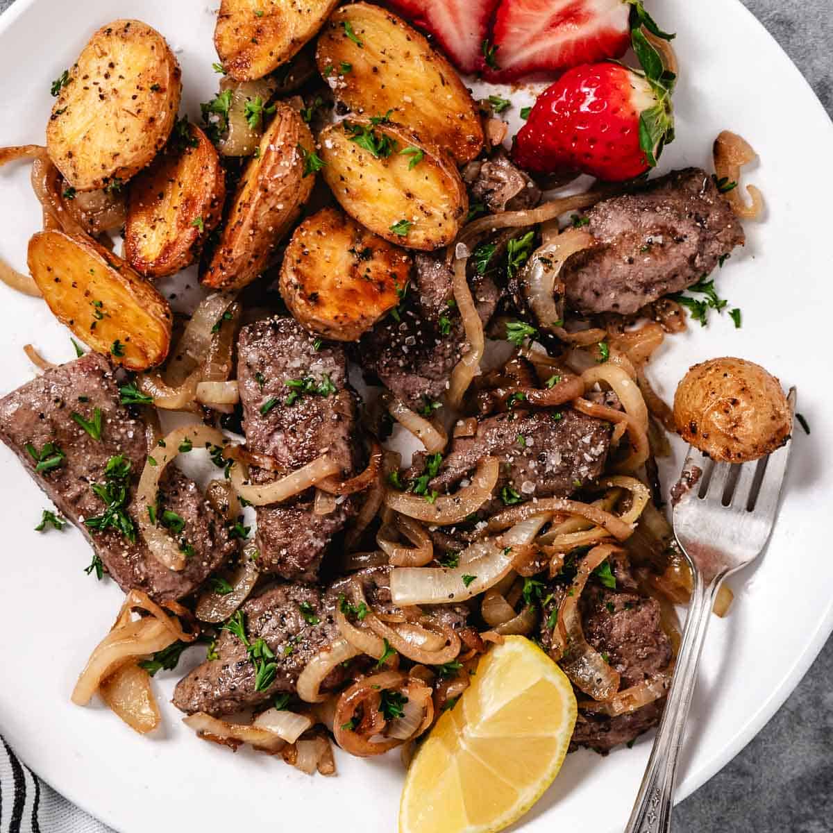Sauteed liver and onions with strawberries and lemon.