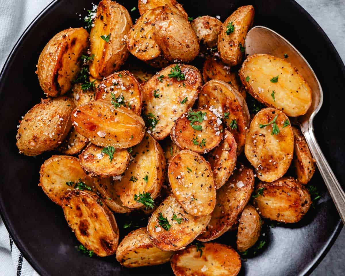 Roasted potatoes with seasonings in a bowl.