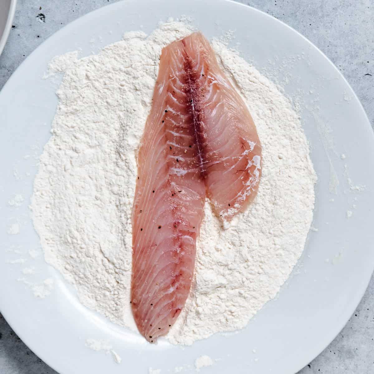 Fish on a plate of flour.