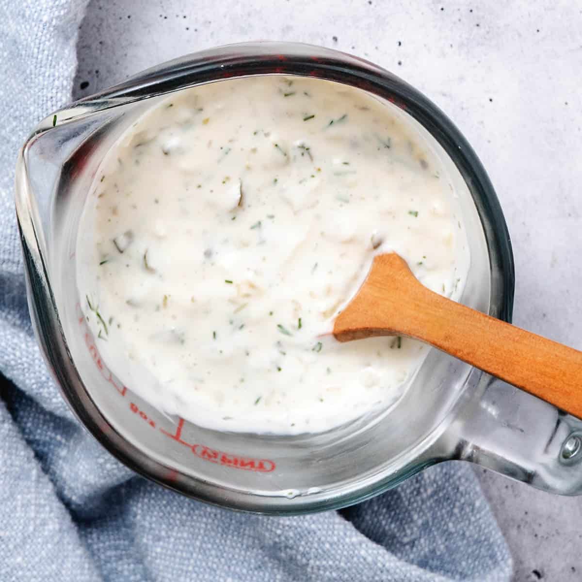 Mixing tartar sauce ingredients in a measuring cup.