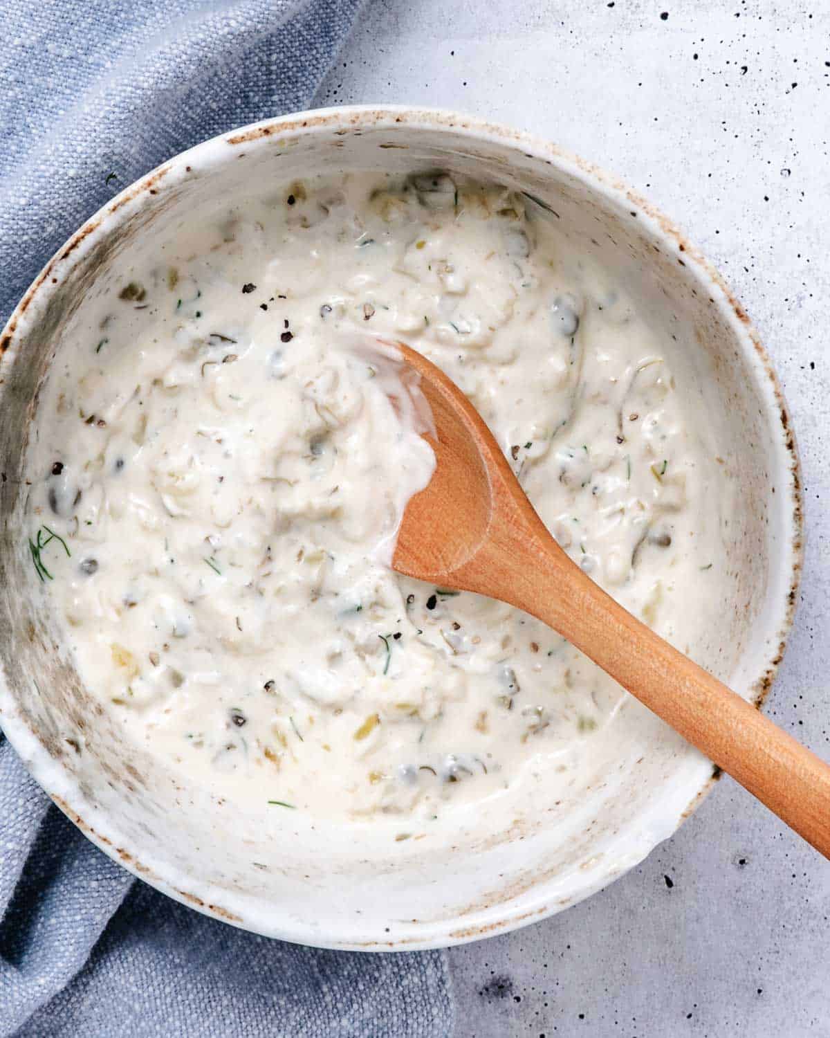 Mixing tartar sauce ingredients in a bowl.