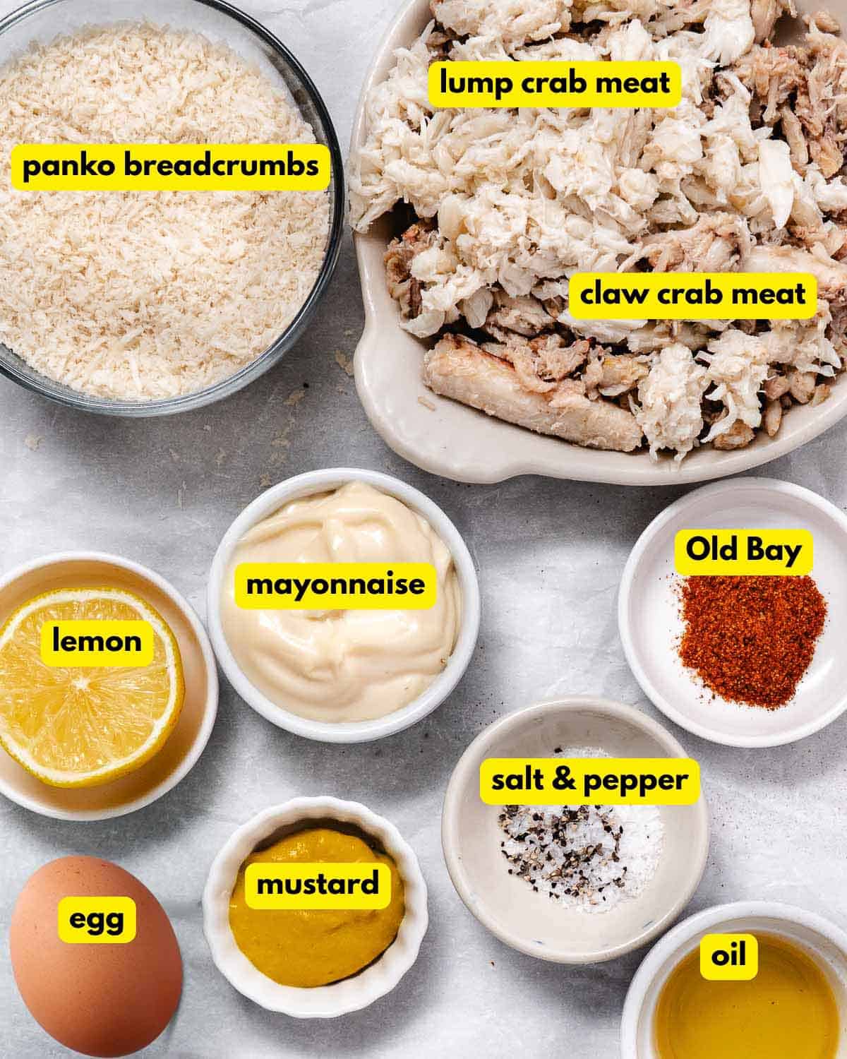 Ingredients for claw meat crab cakes, including lump and claw crabmeat, panko, mayonnaise, egg, mustard, lemon, and Old Bay.