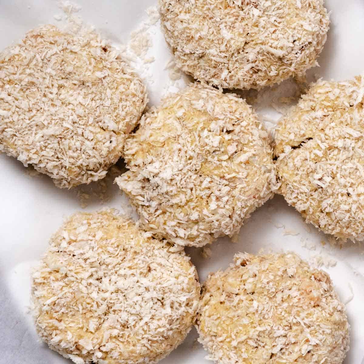 Uncooked lump and claw crab cakes coated with panko breadcrumbs.